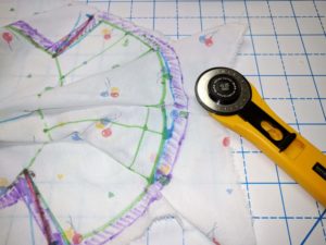 Using rotary cutter to trim off excess fabric